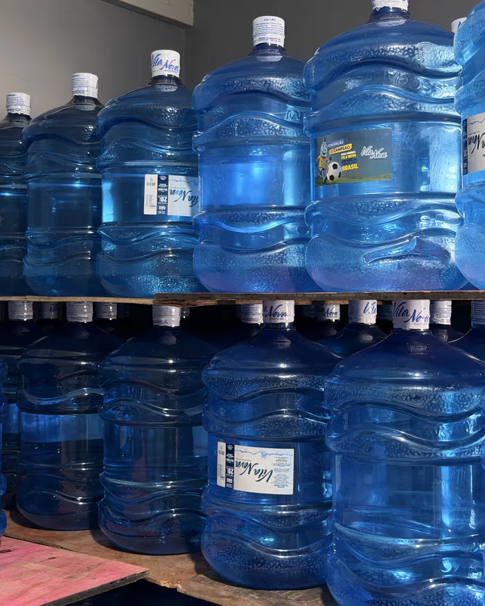 Galões de água mineral de 20 litros empilhados para entrega